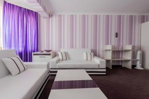 斯莫梁Семеен хотел Кристал的客厅配有2张白色沙发和紫色窗帘
