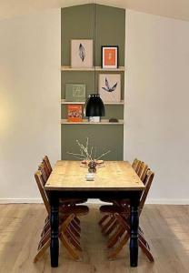AskebyPia´s Guesthouse的餐桌、三把椅子和书架
