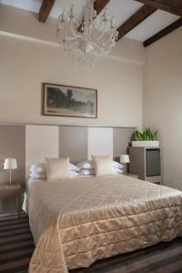 博洛尼亚Albergo Rossini 1936 - Small & Charming的一间卧室配有一张大床和一个吊灯。