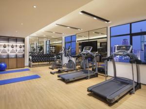 重庆格林东方重庆江北国际机场鹿山地铁站酒店的大楼内带跑步机和健身器材的健身房