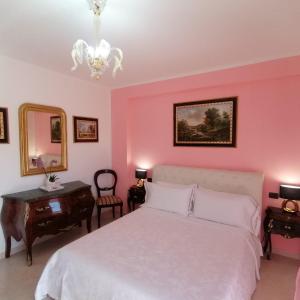 奇维塔韦基亚B&BYanet's Beautiful House的卧室配有白色的床和粉红色的墙壁