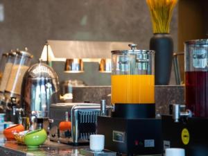 武清格林东方天津武清区万达广场酒店的一个带橘子液体搅拌机的厨房台