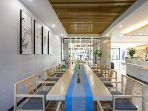 滁州格林东方滁州市政府花园东路酒店的一间带长桌和椅子的用餐室