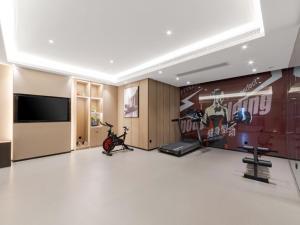 武汉格林东方武汉光谷东湖武汉大学酒店的一间带健身房的房间,配有自行车和电视