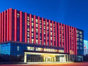 海口格林东方酒店海南自贸港江东新区美兰机场店的一座红色的大建筑,有很多窗户