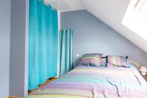 NaveilLa Guinebaudière - Maison avec terrasse的一间卧室配有蓝色窗帘的床
