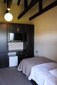 BurreliHotel Vila Bruci的一间卧室配有一张床,厨房配有微波炉