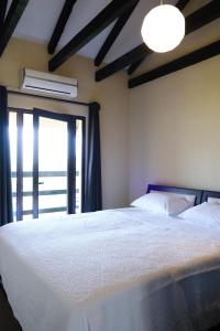 BurreliHotel Vila Bruci的卧室配有一张大白色床和窗户