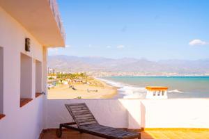 托雷德尔马尔Hostal Paraiso del Mar的俯瞰海滩的阳台的椅子