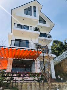 洛伊城Nắng's Villa & Coffee的前面有橙色横幅的建筑