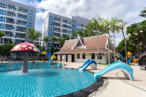 芭堤雅市中心Heeton Concept Hotel Pattaya by Compass Hospitality的一个带滑梯的游泳池和一个游乐场