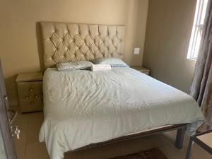 MtubatubaKang B&B的一间卧室配有一张大床和大床头板