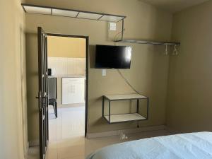 MtubatubaKang B&B的卧室配有镜子和墙上的电视