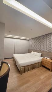 中坜贵都城市商旅的一间卧室配有一张大床和一张桌子