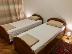 萨拉热窝Guest House Gaj Sarajevo的配有两张单人床的客房,铺有地毯