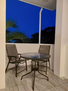 邦劳Bonsai Jacuzzi Suites的晚上在庭院里摆放一张桌子和两把椅子