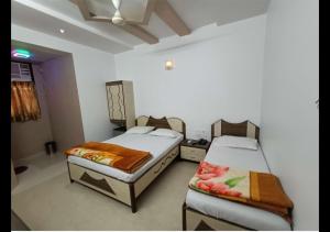 孟买Hotel Broadway Colaba的一间客房内配有两张床的房间