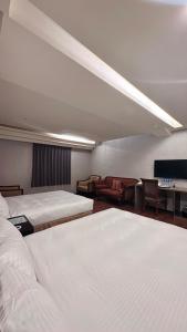 中坜贵都城市商旅的酒店客房,设有两张床和一张沙发