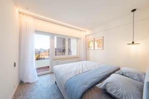 奥斯坦德Luxury Design Apartment with free private parking的一间卧室设有一张床和一个大窗户