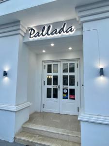 圣加利尼Pallada Hotel的门上方有标志的白色商店前