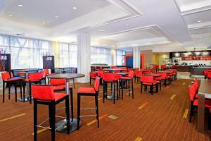 奥克兰奥克兰中心万怡酒店的餐厅设有红色酒吧凳子和桌子