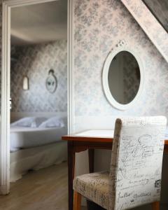 滨海布隆维尔Hôtel De La Mer - Deauville Blonville - Boutique Hôtel de charme vue Mer ou Campagne - Accès direct plage的一间卧室配有桌子、镜子和一张床