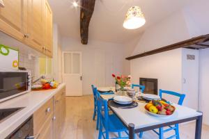 PugernaCasa Gialla - Happy Rentals的厨房配有桌子和蓝色椅子