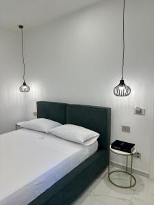 兰佩杜萨Alma Rooms的一间卧室配有绿床和两盏灯