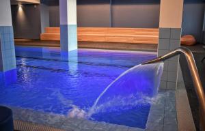 洛阿诺Ai Pozzi Village Resort & SPA的一座建筑物内带喷泉的游泳池