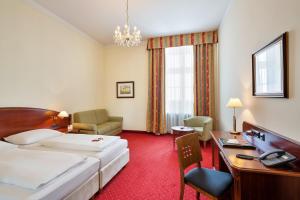 维也纳维也纳市政厅公园奥地利时尚酒店的配有一张床和一张书桌的酒店客房