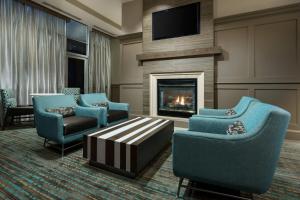 休斯顿休斯顿市中心/会议中心原住客栈的客厅配有蓝色椅子和壁炉
