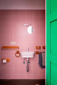 特吉塞Hektor的粉红色的浴室设有水槽和绿门