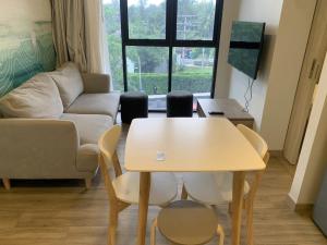 邦涛海滩Apartments in Skypark Laguna Bang Tao的客厅配有桌椅和沙发