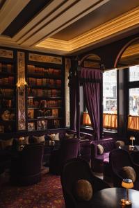 伦敦L'oscar London的藏有紫色沙发和书籍的图书馆