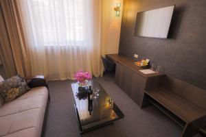 埃里温卡斯凯德酒店 的酒店客房,配有沙发和鲜花桌