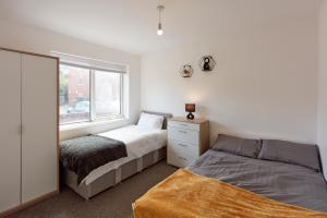 利兹Spacious home close to city centre location的一间卧室设有两张床和窗户。