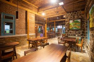 宁平ChezCao Rice Field Ecolodge Ninh Binh的餐厅设有木桌和椅子,拥有砖墙