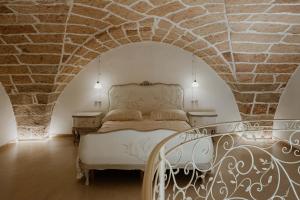 费尔莱恩Borgo Felline Ospitalità Autentica的一间卧室设有一张床和石墙