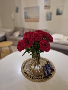 许温凯Lovely studio apartment, glazed balcony and own parking space的一张桌子上满是红玫瑰的花瓶