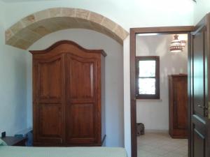 科尔萨诺Mirto的一间设有木门的房间和一间卧室