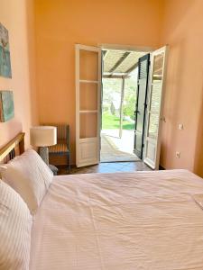 加夫里翁Villa Il Paradiso Andros的一间卧室设有一张床和一个滑动玻璃门