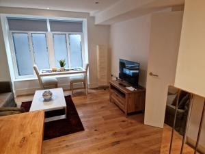 伦敦Lovely 1-Bed Apartment in London的带沙发、电视和桌子的客厅