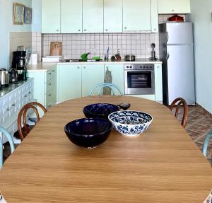加夫里翁Villa Il Paradiso Andros的厨房配有木桌和2个碗