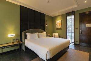 清迈Hotel Loy Chiang Mai的卧室设有一张白色大床和绿色的墙壁