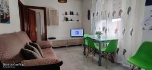 维多利亚-加斯特伊兹Gasteiz Etxea Il的客厅配有桌子和绿色椅子