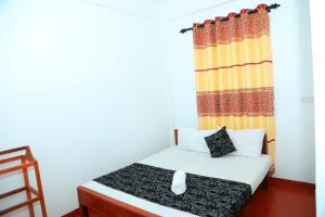 亭可马里White Diamond Resort的一间带床和窗帘的小卧室