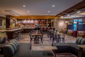 格林斯伯勒格林斯博罗机场万怡酒店的一间带桌椅的餐厅和一间酒吧