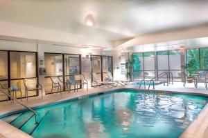 格林斯伯勒格林斯博罗机场万怡酒店的一座配有桌椅的酒店游泳池
