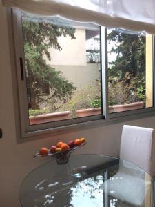 艾日Appartamento "Renata" in residence Cap Roux Eze Borde de Mer Costa Azzurra的窗户前玻璃桌上的一碗水果