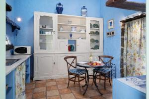 马赫El Piccolo的厨房拥有蓝色的墙壁,配有桌椅